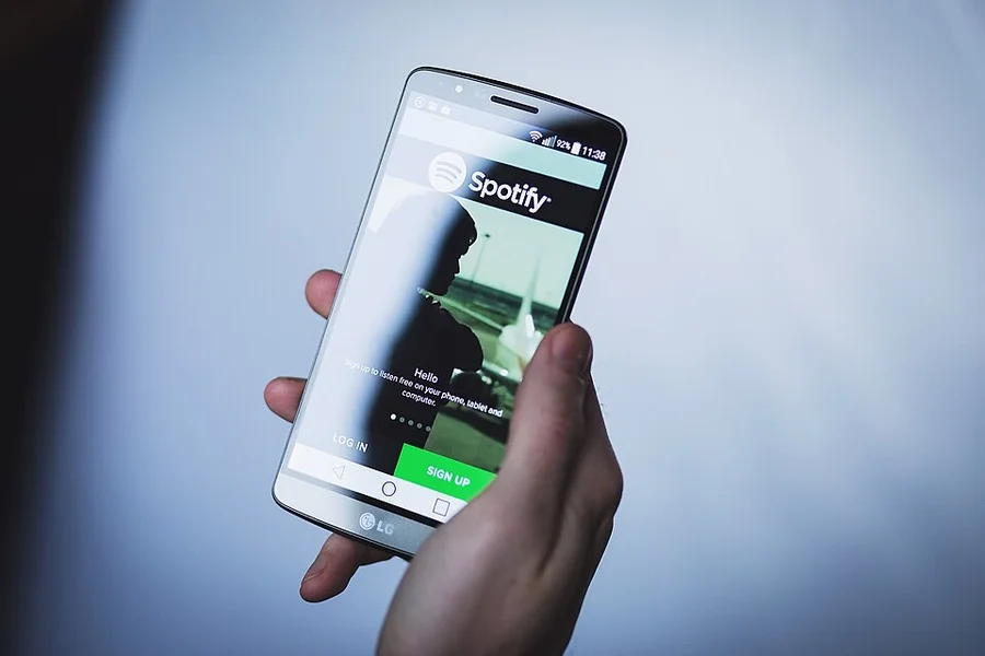 Смартфон с приложением Spotify в руке