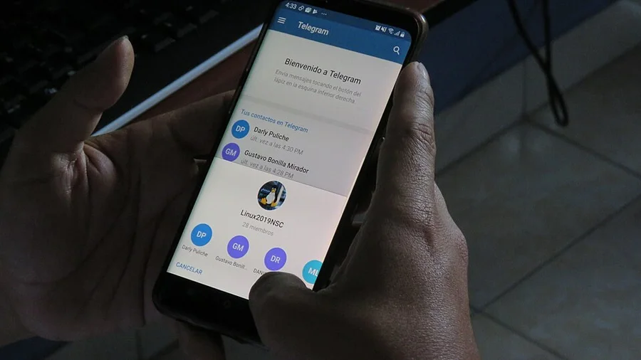 Смартфон с открытым Telegram в руках