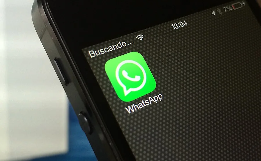 Значок WhatsApp на экране смартфона с надписью о поиске сети